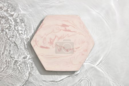 Foto de Podio de mármol vacío sobre textura transparente de agua clara y tranquila con salpicaduras y olas a la luz del sol para publicidad de productos - Imagen libre de derechos