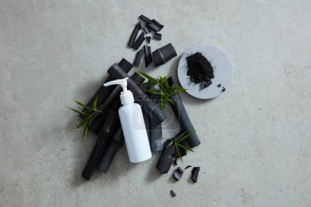 Photo for A bird's-eye view of black bamboo with few green leaves, a beauty product made of activated charcoal mockup - Royalty Free Image