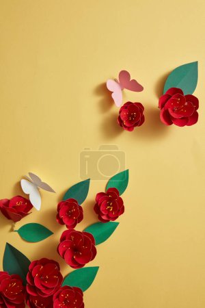 Photo for Over a yellow background, several red blossoms are embellished. Top view, overhead. Empty area for product advertisement. Spring concept mockup - Royalty Free Image