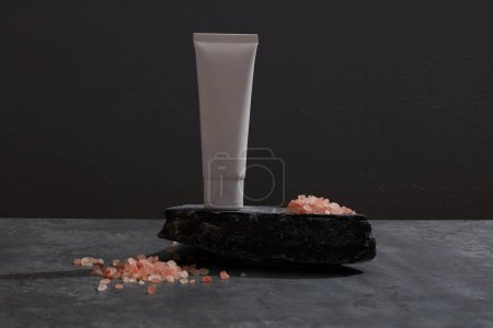 Téléchargez les photos : Vue de face du sel rose et cosmétique décoré en fond noir - en image libre de droit
