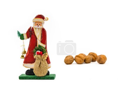 Téléchargez les photos : Figurine en bois du Père Noël et noix découpées en studio tournées sur fond blanc à utiliser comme modèle - en image libre de droit