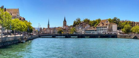 Foto de View from the Muehlsteg on the Limmatquai, the Rudolf Brun Bridge and the Churches of St. Peter and Fraumuenster in Zurich, Switzerland - Imagen libre de derechos