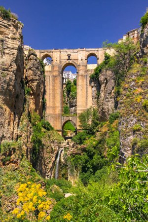 Foto de El llamativo Puente Nuevo sobre el desfiladero de la localidad de Ronda en Andalucía al sol, España - Imagen libre de derechos
