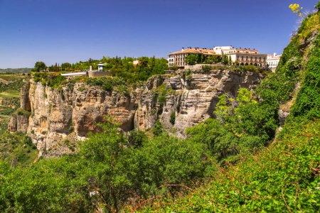 Foto de Los acantilados rocosos sobre los que se construye la ciudad de Ronda en Andalucía bajo el sol y el cielo azul, España - Imagen libre de derechos