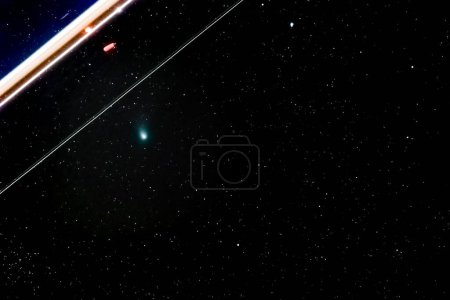 Photo for Long time exposure of Green Comet C 2022 E3 ZTF in the night sky with tracer of an airplane at 428mm on February 12, 2023 near Darmstadt, Germany - Royalty Free Image