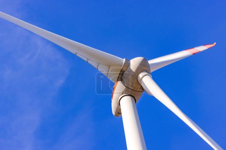 Téléchargez les photos : Détails du rotor et des pales d'une éolienne recadrées devant un ciel bleu - en image libre de droit