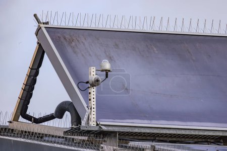 Sonnenkollektoren mit Spikes zur Taubenabwehr auf dem Dach eines Hauses mit Wärmesystem zur Erwärmung von Wasser