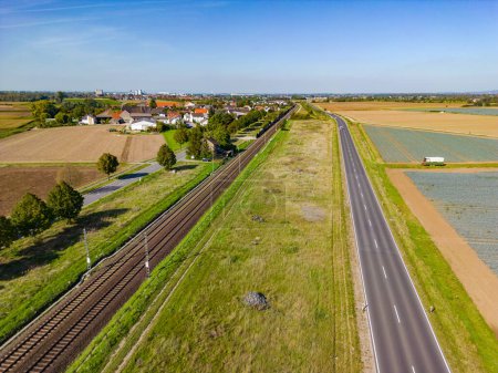 Drohnenperspektive ländliche Straßen- und Eisenbahnstrecke auf dem Land, Luftaufnahme in Deutschland