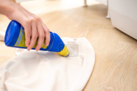 Foto de Detergente de mano femenina de primer plano para eliminar manchas severas en la ropa - Imagen libre de derechos