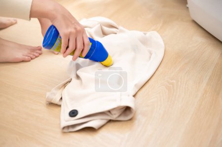 Foto de Detergente de mano femenina de primer plano para eliminar manchas severas en la ropa - Imagen libre de derechos
