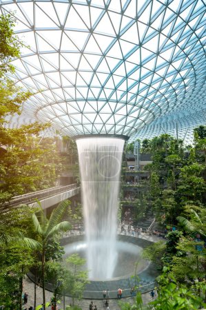 Changi, Singapore - 26/12/2022 : Jewel Changi Airport , artificial waterfall dome with plants where is most famous eco landmark combined with shopping mall in Changi Airport .