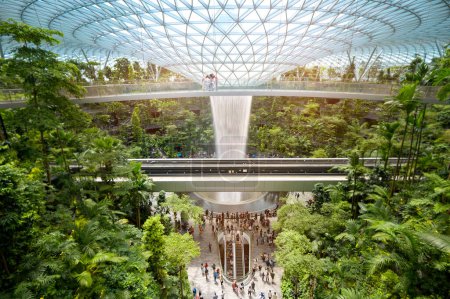 Téléchargez les photos : Changi, Singapore - 26/12/2022 : Jewel Changi Airport , artificial waterfall dome with plants where is most famous eco landmark combined with shopping mall in Changi Airport . - en image libre de droit