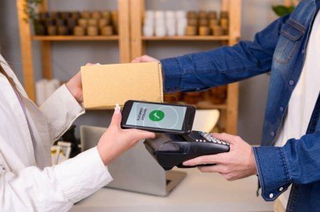 client femme utilisant le paiement par code QR via smartphone pour payer à la boutique 