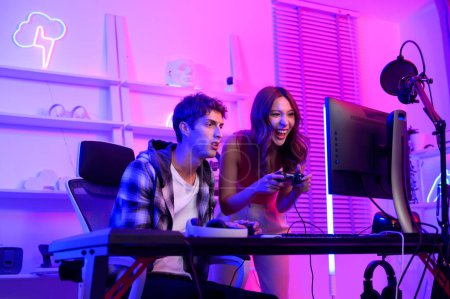 Foto de Jóvenes profesionales juegan videojuegos juntos transmitiendo sus partidos en directo y hablan con sus fans en sus casas. - Imagen libre de derechos