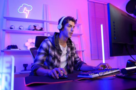 Photo for Young Caucasian man Pro Gamer have live streaming  and chatting  with his  fans at home - Royalty Free Image