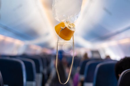 Sauerstoffmaske fällt im Flugzeug aus dem Deckenfach