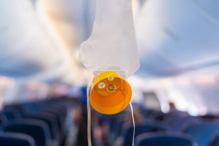 Photo for Oxygen mask drop from the ceiling compartment on airplane - Royalty Free Image
