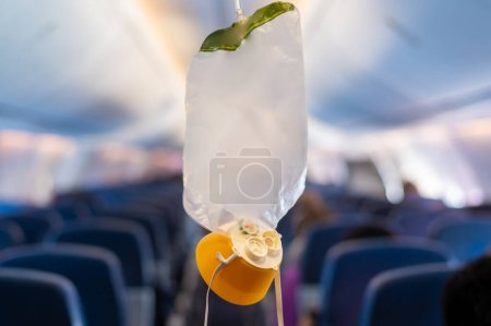Téléchargez les photos : Masque à oxygène tomber du compartiment du plafond sur l'avion - en image libre de droit
