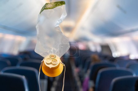 Téléchargez les photos : Masque à oxygène tomber du compartiment du plafond sur l'avion - en image libre de droit
