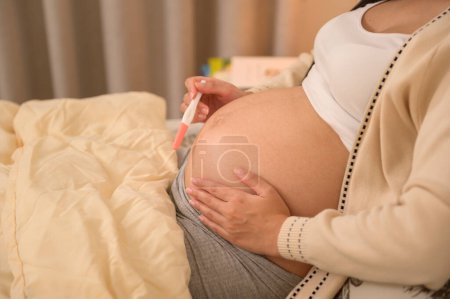 Schöne schwangere Frau mit positivem Schwangerschaftstest, Fruchtbarkeitsbehandlung, IVF, zukünftiges Mutterschaftskonzept