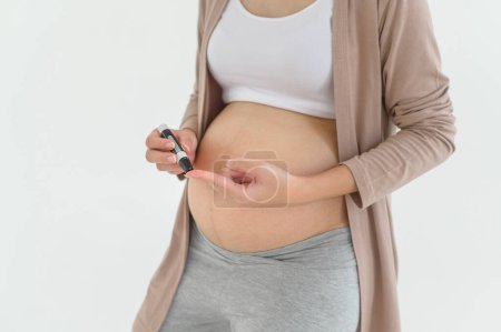 Schwangere überprüfen den Blutzuckerspiegel mittels digitalem Blutzuckermessgerät, Gesundheitsfürsorge, Medizin, Diabetes, Glykämie-Konzept
