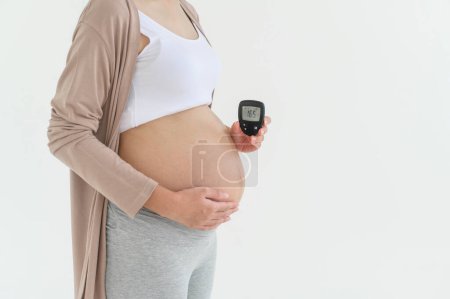 Mujer embarazada comprobando el nivel de azúcar en sangre mediante el uso de medidor de glucosa digital, atención médica, medicina, diabetes, concepto de glucemia