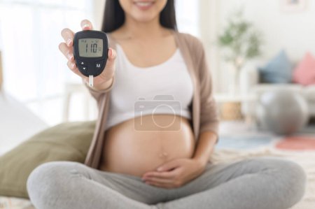 Mujer embarazada comprobando el nivel de azúcar en sangre mediante el uso de medidor de glucosa digital, atención médica, medicina, diabetes, concepto de glucemia