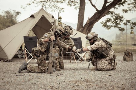 Soldados en uniformes de camuflaje planeando la operación en el campo, soldados entrenando en una operación militar