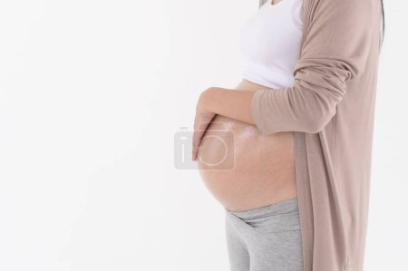 Schöne schwangere Frau Anwendung feuchtigkeitsspendende, Dehnungsstreifen Creme auf dem Bauch, Fruchtbarkeitsbehandlung Unfruchtbarkeit, IVF, zukünftige Mutterschaftskonzept