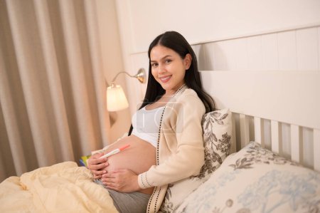 Hermosa mujer embarazada con prueba de embarazo positiva, tratamiento de infertilidad de fertilidad, FIV, futuro concepto de maternidad