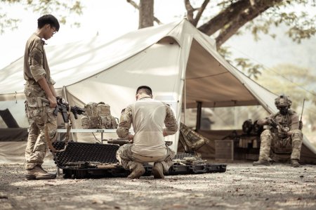 Soldados en uniformes de camuflaje planeando la operación en el campamento
