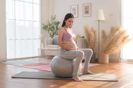 Téléchargez les photos : Femme enceinte saine faisant de l'exercice et faisant du yoga prénatal, de la méditation, de l'exercice, du yoga, concept de grossesse. - en image libre de droit