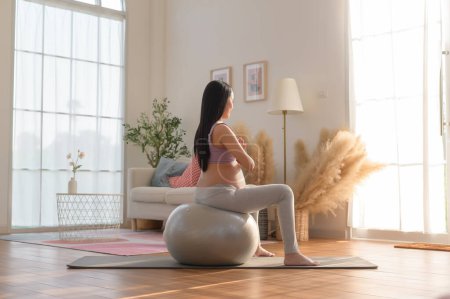 Téléchargez les photos : Femme enceinte saine faisant de l'exercice et faisant du yoga prénatal, de la méditation, de l'exercice, du yoga, concept de grossesse. - en image libre de droit