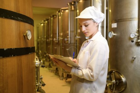 Enólogo profesional que controla el proceso de elaboración del vino y la calidad en la fábrica de la bodega