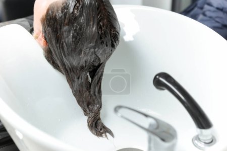 Photo for The hairdresser washes the hair of the client in the salon, medium side view, close-up, beauty concept. High quality photo - Royalty Free Image