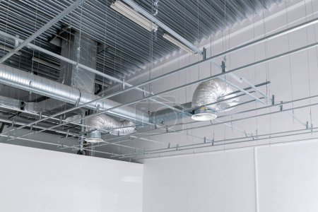 Foto de Sistema de ventilación y aire acondicionado en el techo de un edificio industrial, tubos de ventilación metálica - Imagen libre de derechos