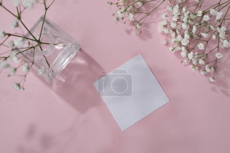 Téléchargez les photos : Blank paper sheet card with mockup copy space, gypsophila flowers and floral sunlight shadows on a pastel pink background. Flat lay, top view minimal business brand template - en image libre de droit