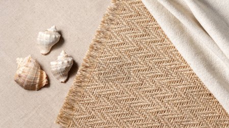 Téléchargez les photos : Minimal aesthetic neutral summer vacation concept with sea shells and jute rug on a beige background, copy space - en image libre de droit