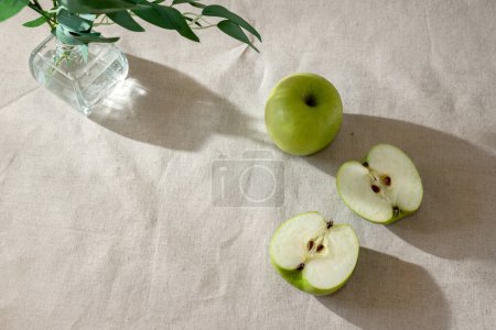 Photo for Green apples on a beige tablecloth, minimalist lifestyle fruit background with copy space - Royalty Free Image