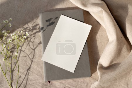 Tarjeta de papel en blanco y bloc de notas sobre un fondo beige neutro, plantilla estética de marca natural con espacio para copiar