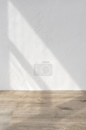 Sun light shadows on a white textured wall and beige wooden floor, blank design template for home room interior or product stand mock up, business brand advertisement background, copy space Poster 652571186