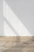 Sun light shadows on a white textured wall and beige wooden floor, blank design template for home room interior or product stand mock up, business brand advertisement background, copy space Poster #652571186