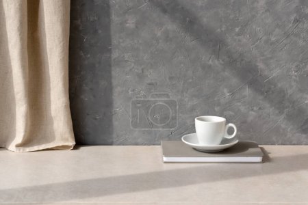 Foto de Minimalista estética sostenible casa naturaleza muerta con taza de café en la mesa beige neutro, con una cortina de lino y sombra sobre fondo de pared de hormigón vacío gris, elegante habitación de diseño interior telón de fondo - Imagen libre de derechos