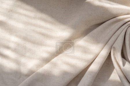 Foto de Fondo textil natural estético con una sombra de luz solar abstracta, tela drapeada de lino beige neutro, espacio para copiar - Imagen libre de derechos