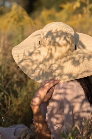 Téléchargez les photos : Concept élégant blog de mode, femme élégante dans un chapeau de paille avec des ombres de soleil esthétiques - en image libre de droit