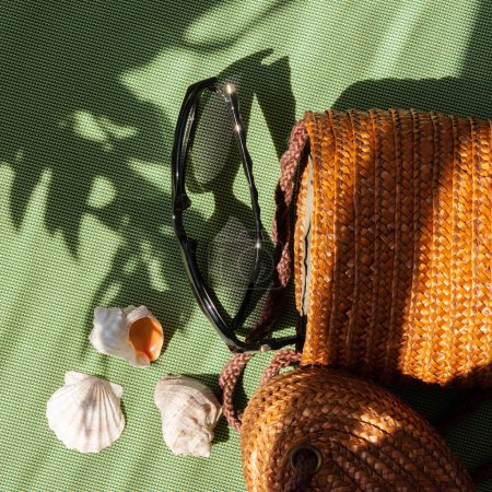 Foto de Blog de moda de verano, marca plana laico, accesorios de mujer con estilo sobre un fondo verde, conchas de mar, gafas de sol, bolsa con sol floral sombra de luz - Imagen libre de derechos