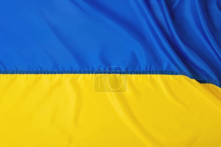 Foto de Símbolo nacional de Ucrania país, gobierno. Día de la independencia, concepto de libertad, plantilla con espacio de copia. Bandera de la bandera de Ucrania, fondo de textura de tela de seda plegada azul amarillo. - Imagen libre de derechos