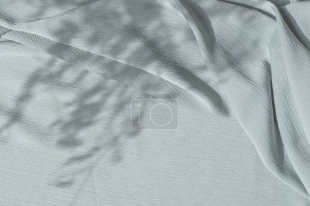 Photo for Light blue fabric texture with folds and natural floral sunlight shadows. Aesthetic summer wedding bohemian background - Royalty Free Image