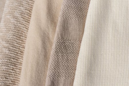 Foto de Beige, taupe, marrón claro, lana cremosa, algodón y cachemira mezcla suéteres de punto textura pila juntos, ropa de otoño de color neutro cálido, concepto de armario de punto - Imagen libre de derechos