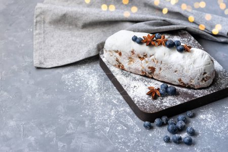 Foto de Stollen, fiesta casera tradicional panadería europea de Navidad, pastel de frutas festivas con arándanos, pasas, anís y azúcar en polvo a bordo - Imagen libre de derechos
